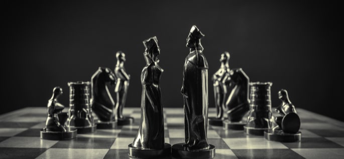 king and queen chess pieces on a chessboard